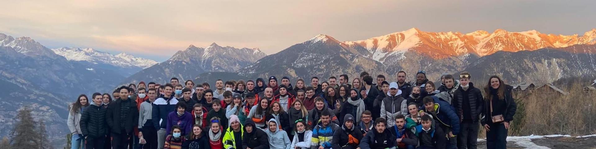 Photo de groupe du ski devant les montagnes